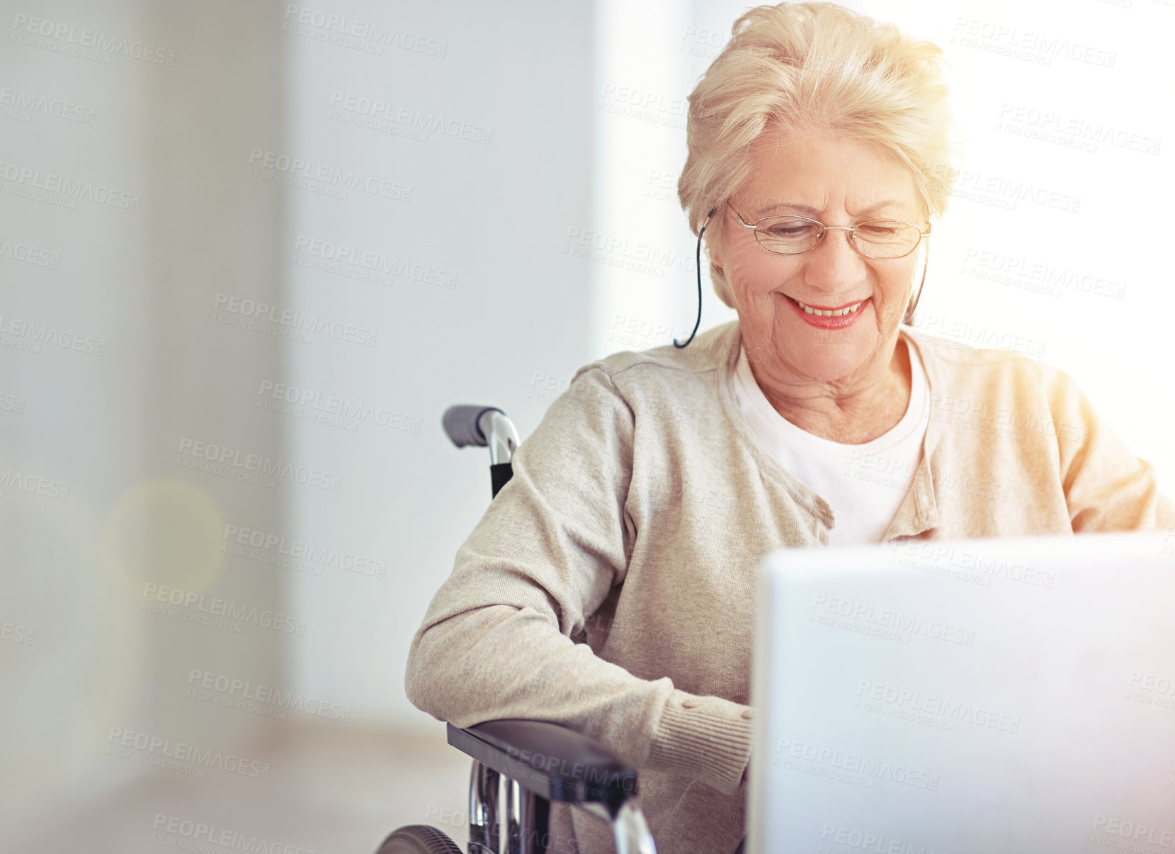 Buy stock photo Shot of a senior woman using a laptop while sitting in a wheelchair