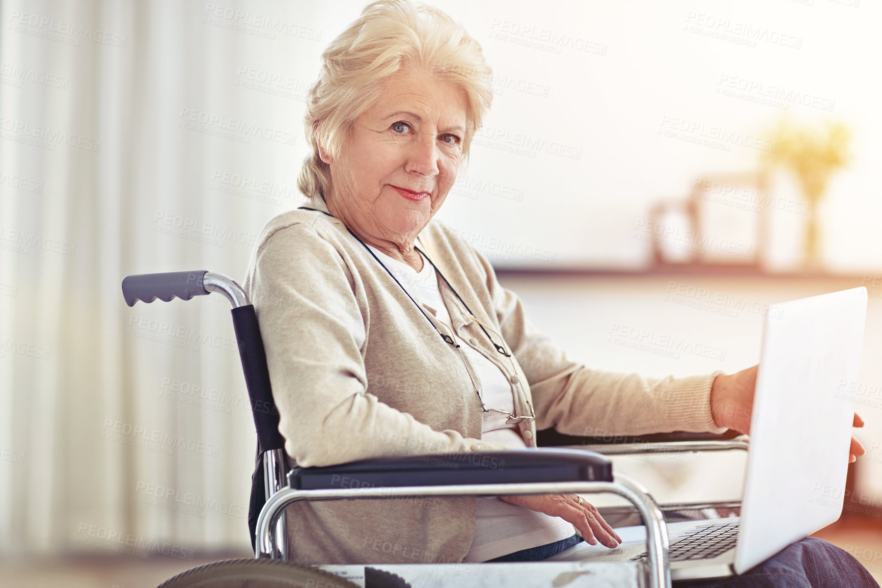 Buy stock photo Shot of a senior woman using a laptop while sitting in a wheelchair