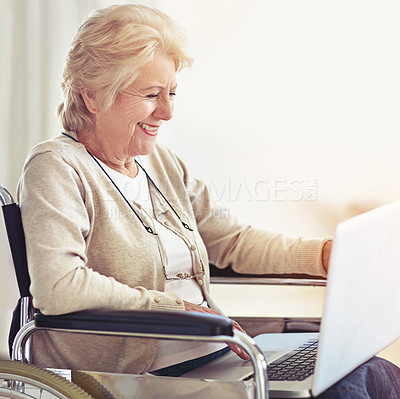 Buy stock photo Shot of a senior woman using a laptop while sitting in a wheelchair