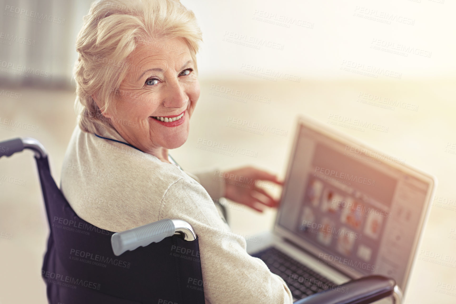 Buy stock photo Shot of a senior woman using a laptop while sitting in a wheelchair