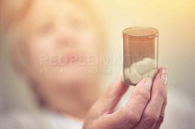 Buy stock photo Cropped shot of an elderly woman holding a container of medicine