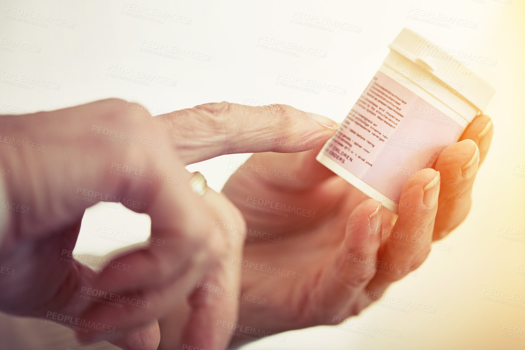 Buy stock photo Cropped shot of an elderly woman checking the container of medicine she;s holding