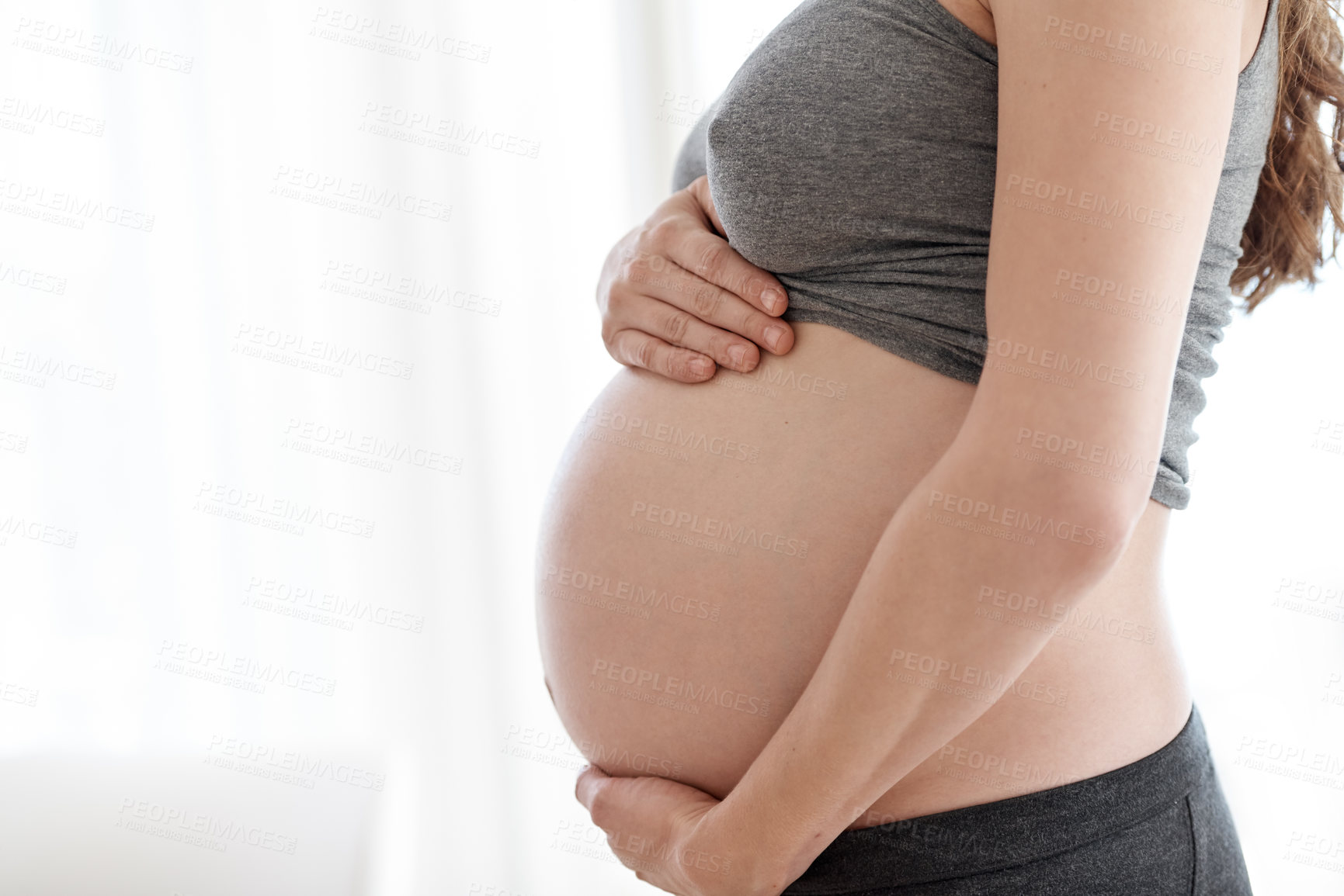 Buy stock photo Cropped shot of a pregnant woman standing in her home