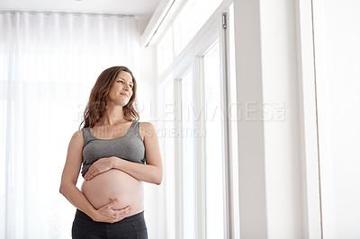 Buy stock photo Cropped shot of a young pregnant woman standing in her home