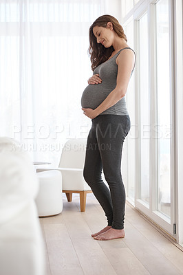 Buy stock photo Full length shot of a young pregnant woman standing in her home