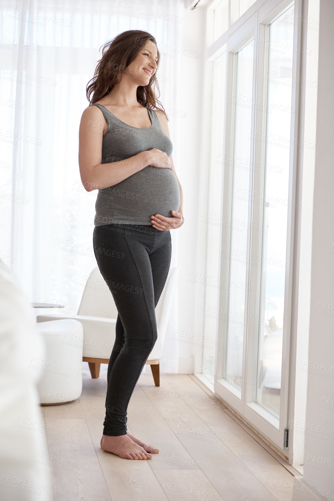 Buy stock photo Full length shot of a young pregnant woman standing in her home