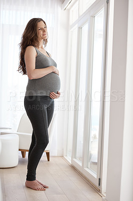 Buy stock photo Full length shot of a young pregnant woman standing in her home