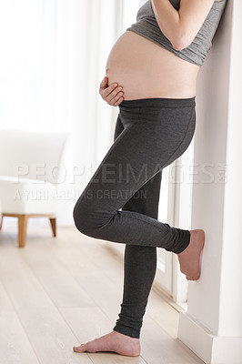 Buy stock photo Cropped shot of a pregnant woman standing in her home