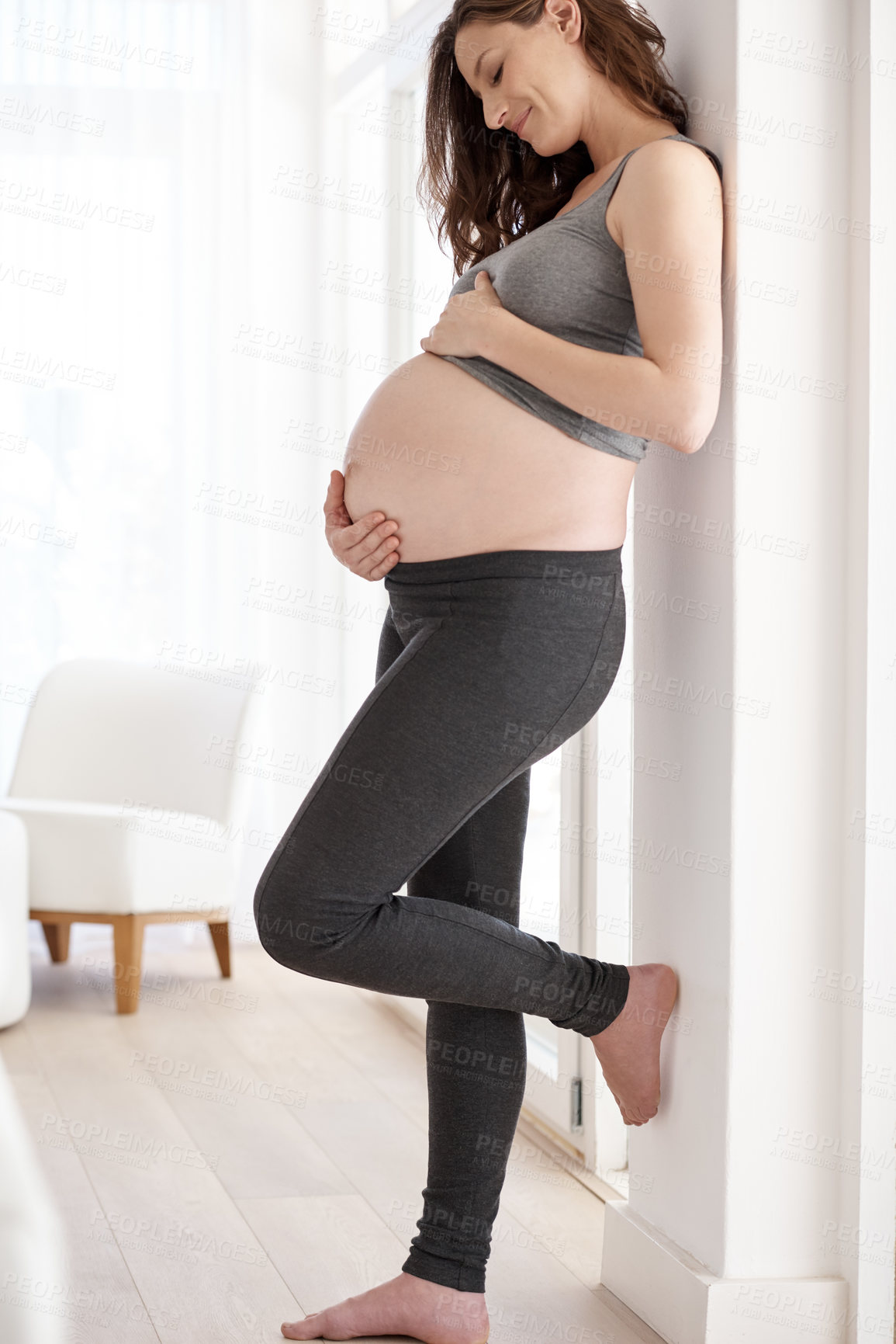 Buy stock photo Full length shot of a young pregnant woman standing in her home