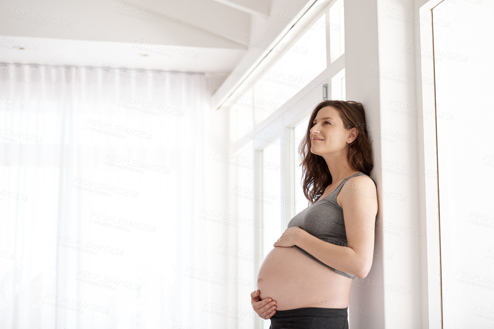 Buy stock photo Cropped shot of a young pregnant woman standing in her home