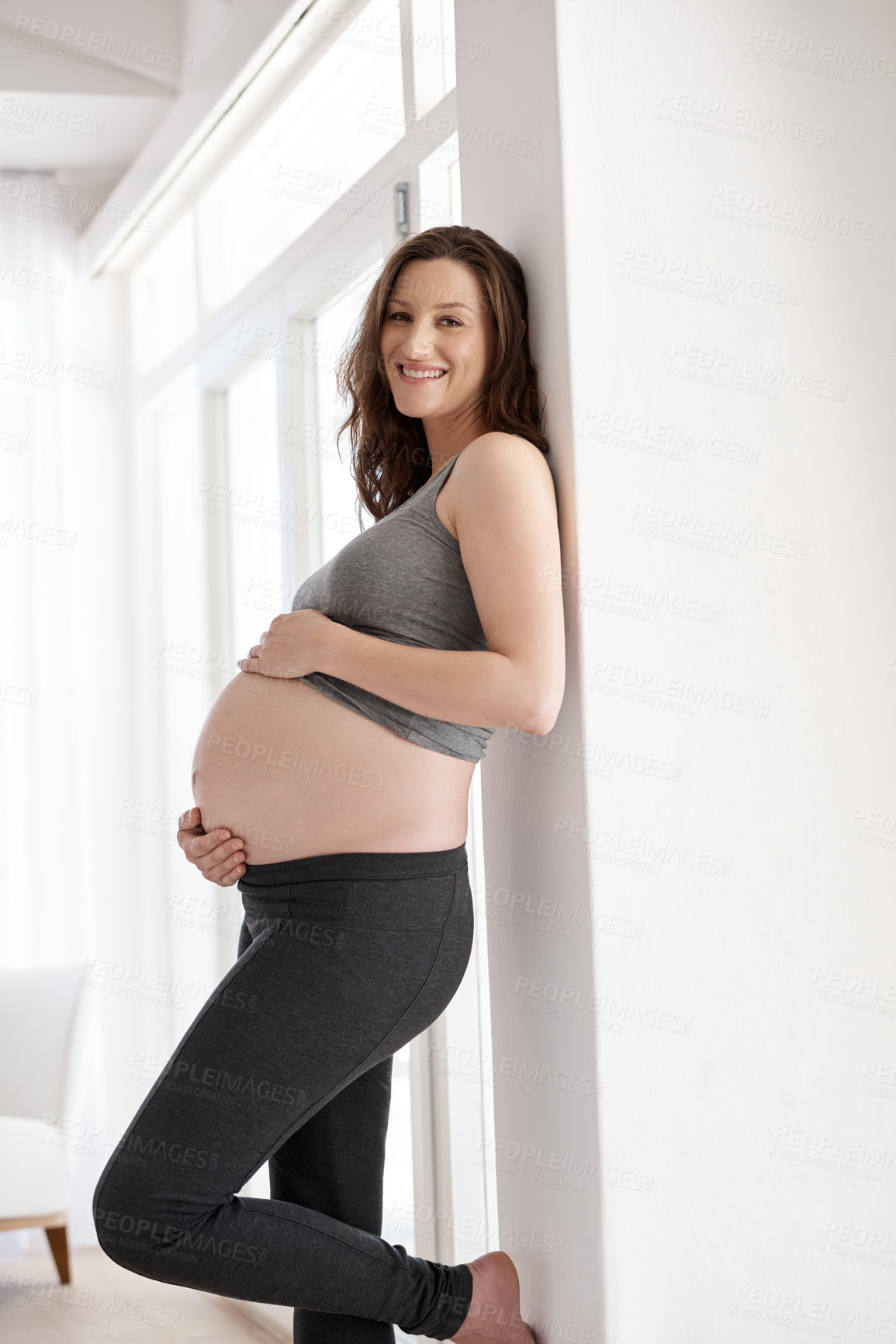 Buy stock photo Cropped portrait of a young pregnant woman standing in her home