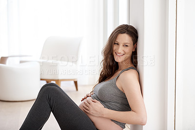 Buy stock photo Cropped shot of a young pregnant woman sitting in her home