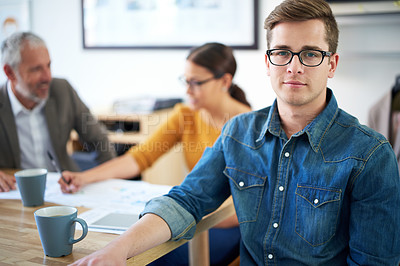 Buy stock photo Portrait of a young businessman with his colleagues working in the background