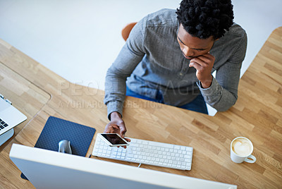 Buy stock photo High angle shot of a young male designer at his desk
