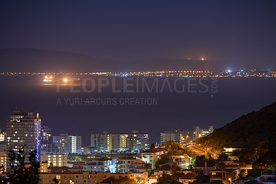 Buy stock photo Cityscape, night and ocean or urban landscape with buildings, boat and sea or outdoor. Development, skyline and port or light for shipping, cargo and tourism or travel for architecture or hospitality