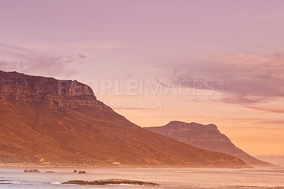 Buy stock photo A mountain and sea side against sky and sunset copyspace background. Sunrise scenic ocean view with copy space, Hout Bay harbour with an ocean view, perfect getaway for a trip or seaside vacation 