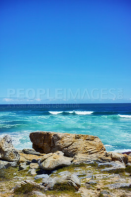 Buy stock photo Ocean, coast and rocks in nature outdoor for travel destination, coat environment and natural beauty. Blue sky, beach and water for seaside hiking, tourism journey with adventure location of view