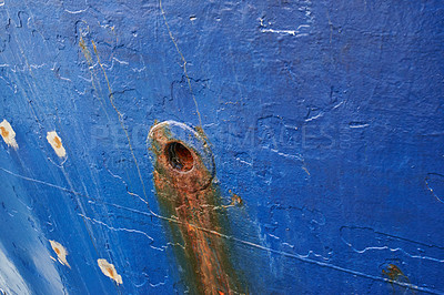 Buy stock photo Abandoned and rusty limber hole on the side of docked ship outside. Closeup of rust stained hawsehole used for draining water on the hull of a nautical boat in a dockyard and port overseas and abroad