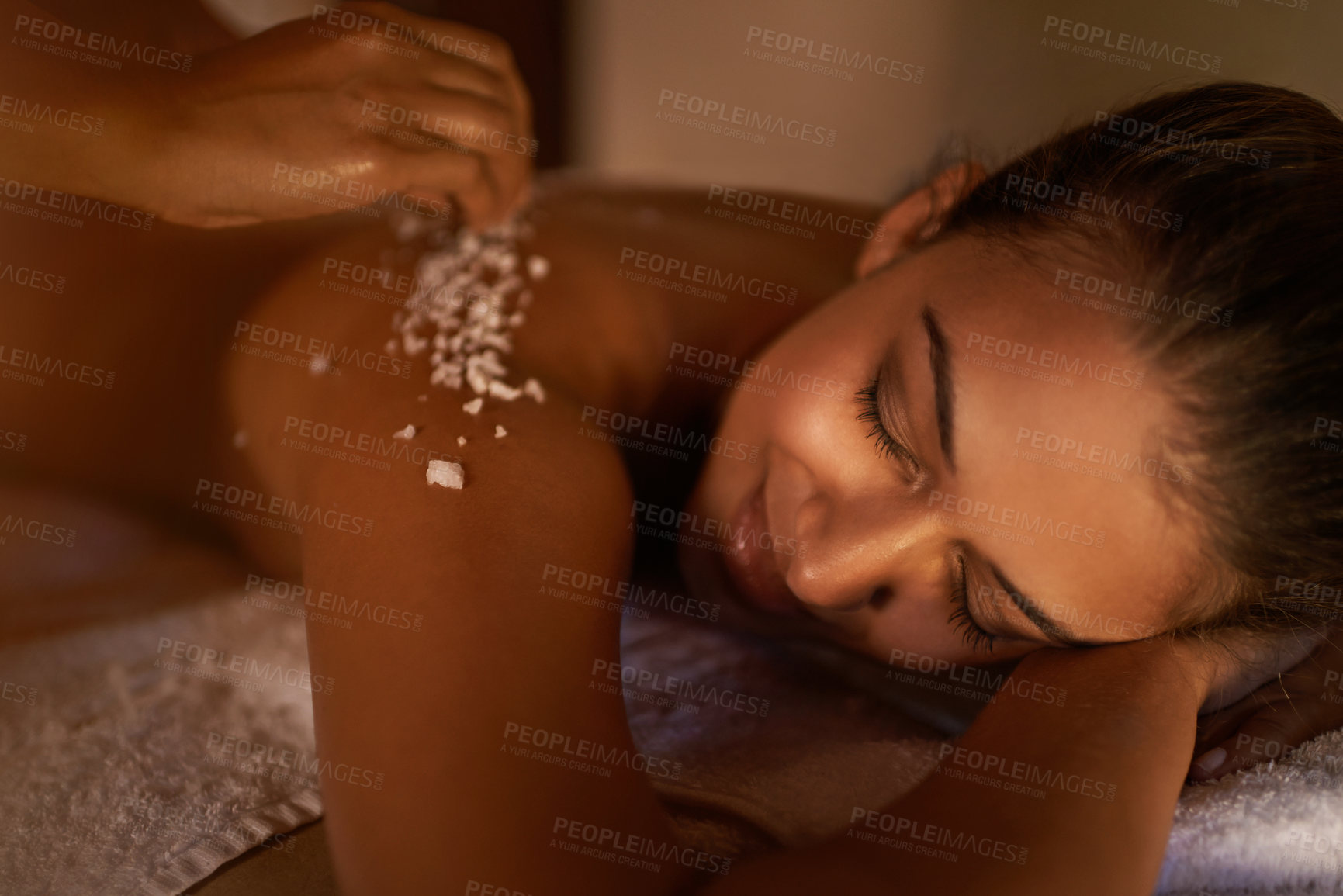 Buy stock photo Spa, skincare and salt massage of a woman smile with beauty specialist with body treatment. Exfoliate, female person back and relax detox application for skin and calm wellbeing at a hotel with care