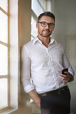 Buy stock photo Cropped portrait of a businessman sending a text in his office