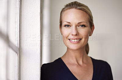 Buy stock photo Cropped portrait of a businesswoman standing by a window in her office