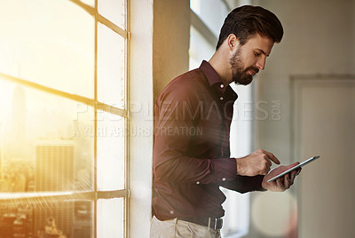 Buy stock photo Cropped shot of a businessman using a digital tablet in his office