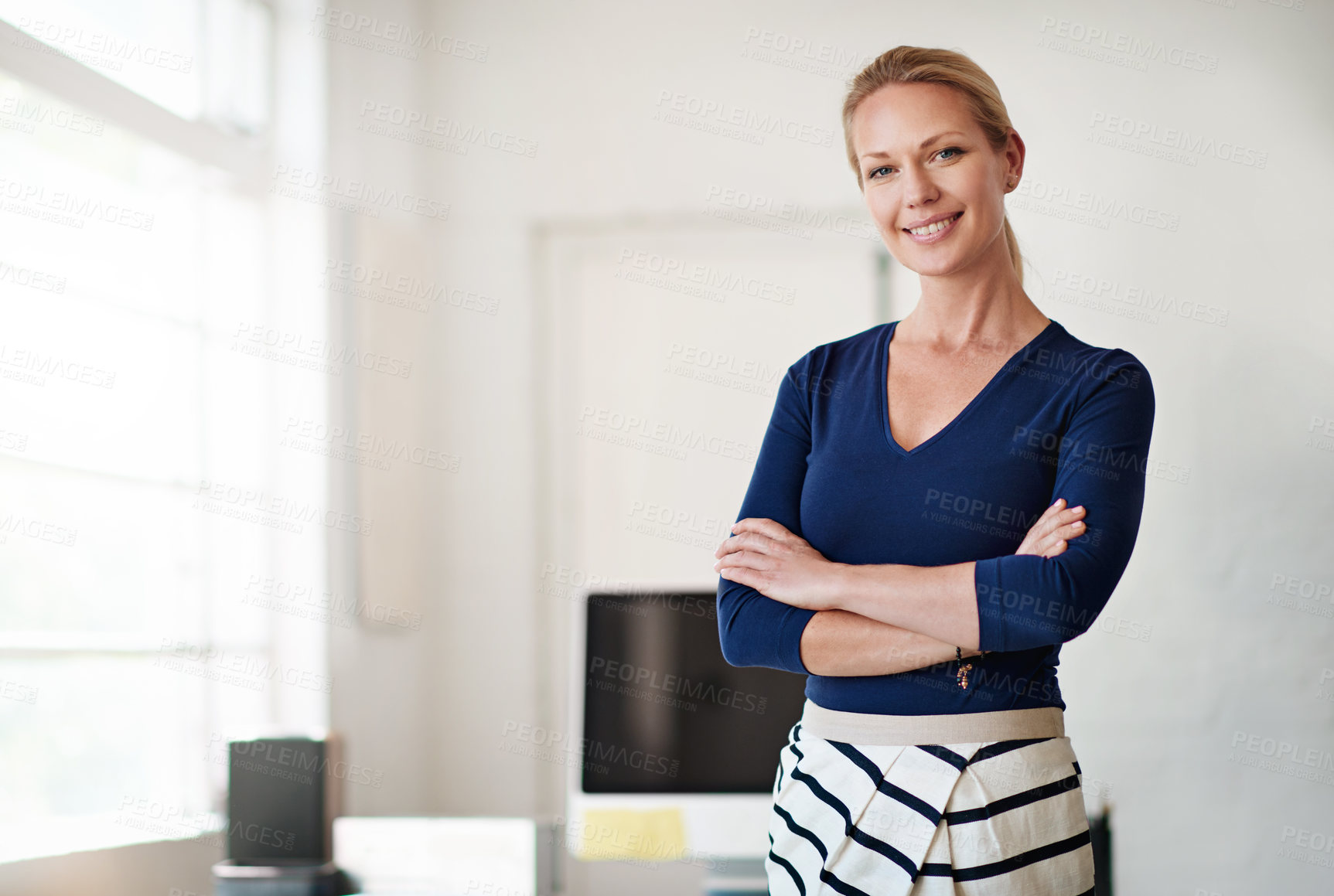 Buy stock photo Cropped portrait of a businesswoman standing with her arms folded in her office