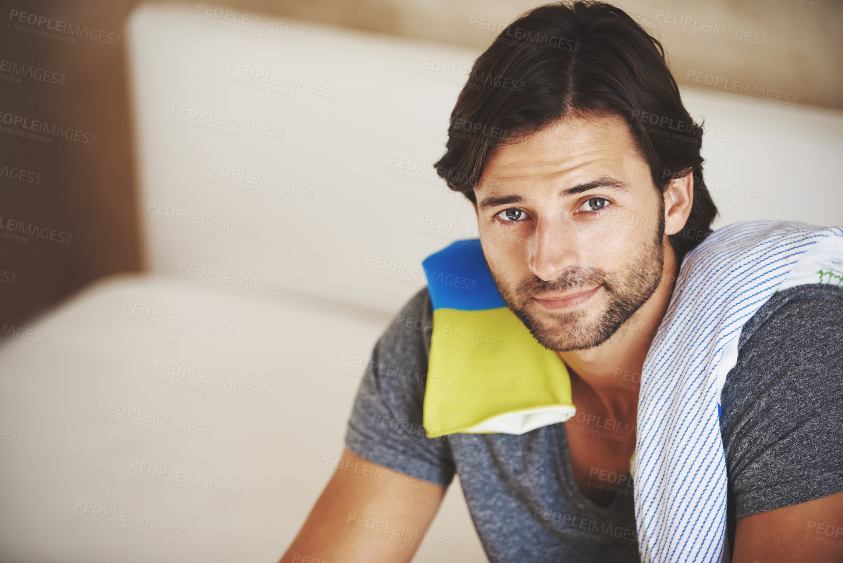 Buy stock photo Shot of a young man sitting at home