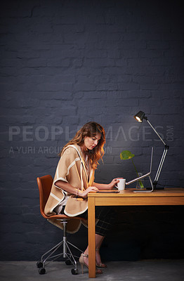 Buy stock photo Shot of a woman working on her digital tablet at a desk
