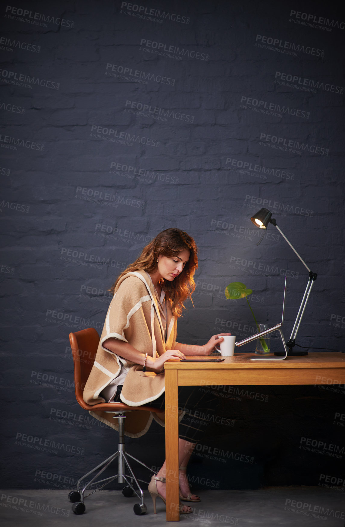 Buy stock photo Shot of a woman working on her digital tablet at a desk