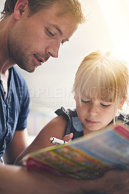 Buy stock photo Shot of a single dad helping his daughter with her homework