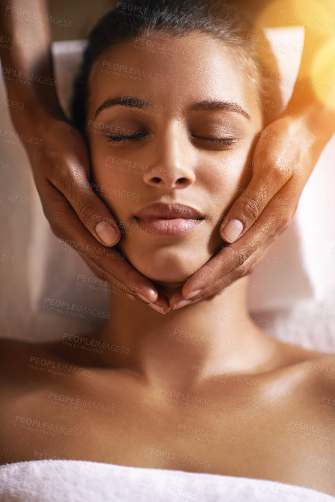 Buy stock photo Woman, spa and facial for massage on face with hands and care for lens flare, wellness and beauty treatment. Above, towel and african female person with skincare and relax at hotel with skin glow 