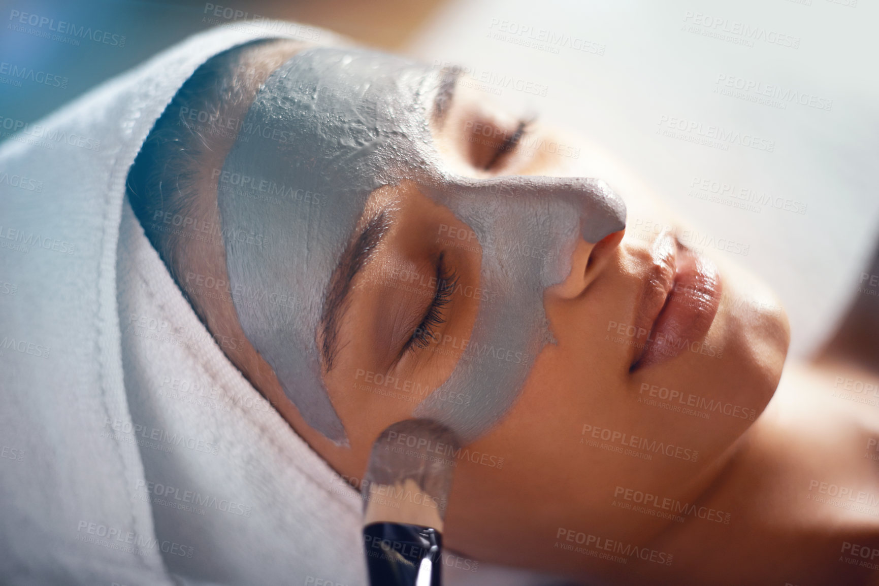 Buy stock photo Shot of a young woman enjoying a facial treatment at a spa