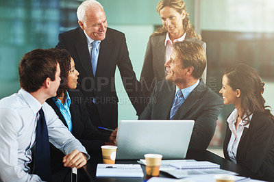 Buy stock photo Cropped shot of a group of businesspeople gathered around a laptop in the office