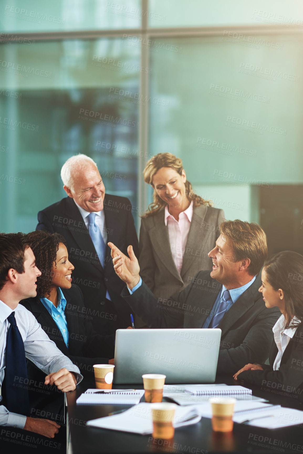 Buy stock photo Cropped shot of a group of businesspeople gathered around a laptop in the office