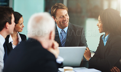 Buy stock photo Cropped shot of a group of businesspeople gathered around a laptop in the office