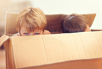 Buy stock photo Two adorable young boys peeking out of a cardboard box