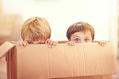 Buy stock photo Children, box and eyes of siblings playing in a house with fun, bonding and hide and seek games. Cardboard, learning and curious kid brothers in a living room with fantasy, imagine or hiding at home