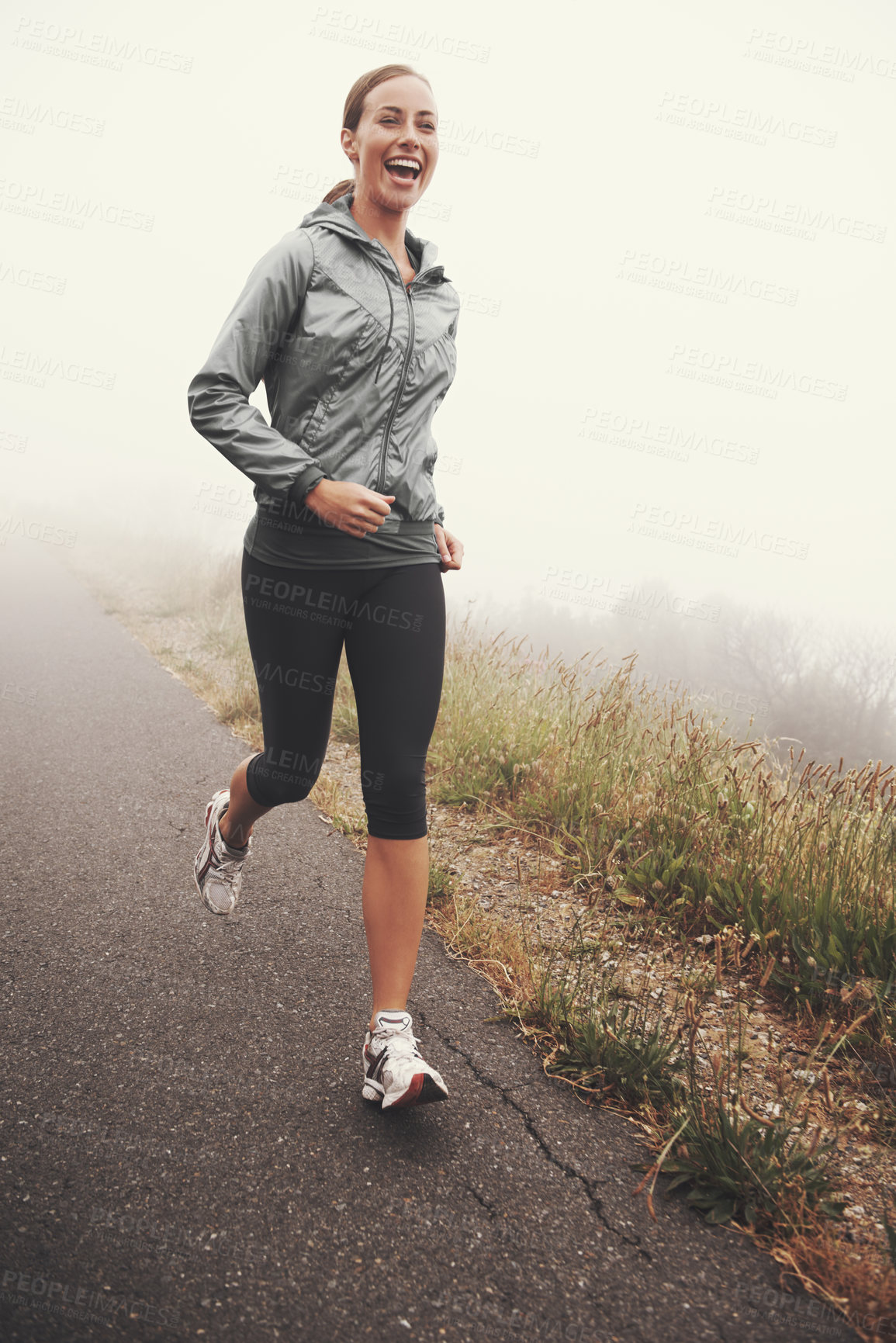 Buy stock photo Happy, woman and running on road outdoor in forest, park or woods for exercise in winter. Morning, fog and person with fitness training and healthy workout on path in mountain countryside with smile