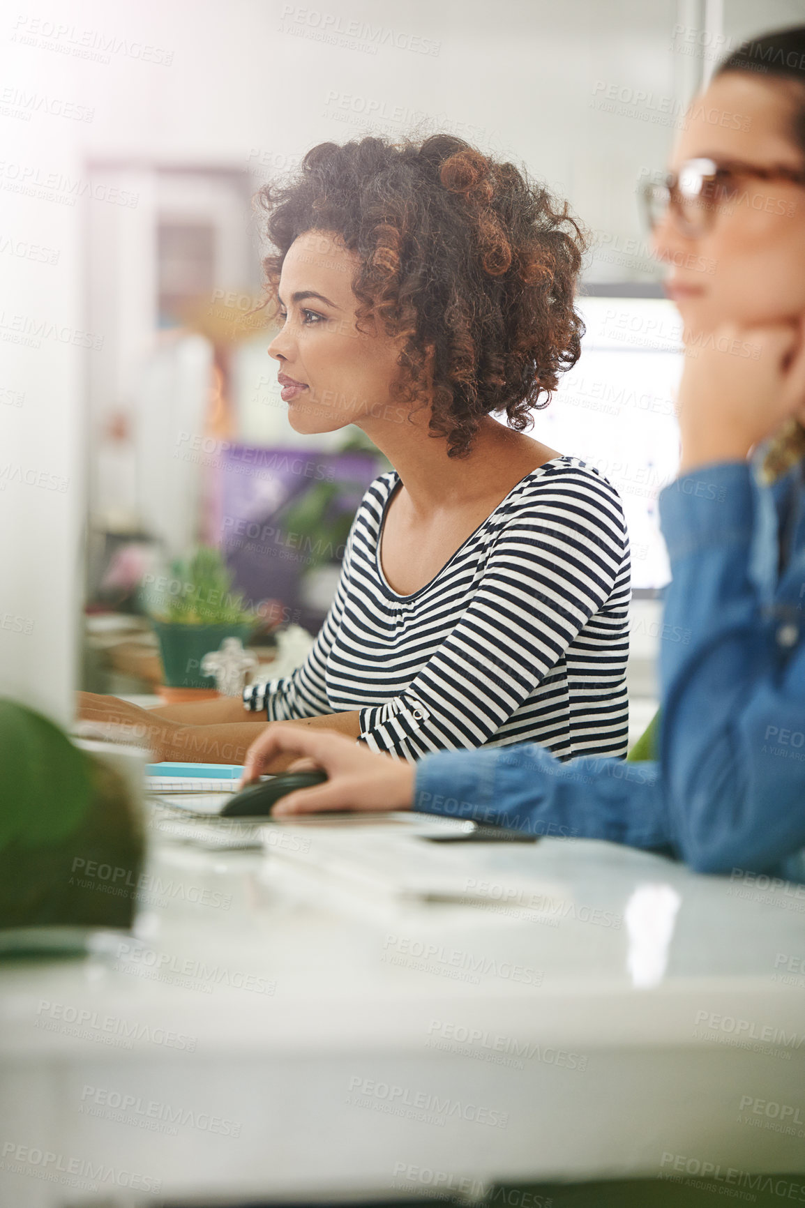 Buy stock photo Cropped shot of two young businesswomen at their desks