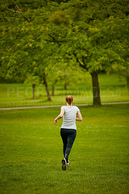 Buy stock photo Shot of a woman jogging in a park