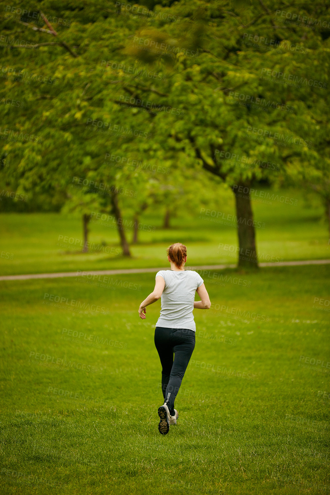 Buy stock photo Shot of a woman jogging in a park