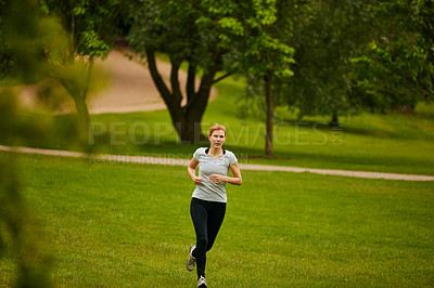 Buy stock photo Shot of a woman jogging in a park