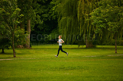 Buy stock photo Shot of a woman jogging in a park