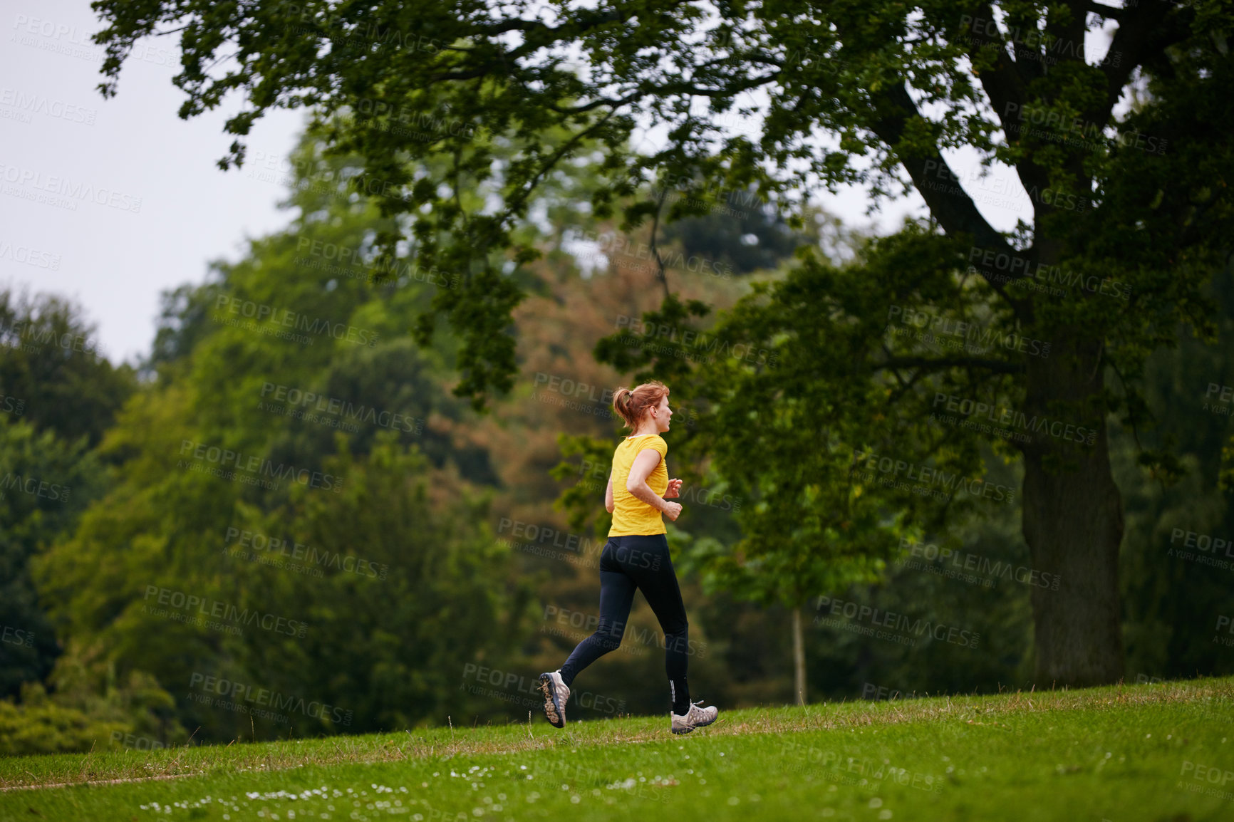 Buy stock photo Shot of a woman jogging in a park