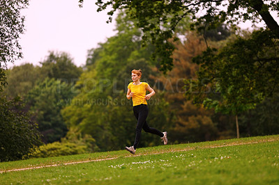 Buy stock photo Shot of a woman jogging in a park