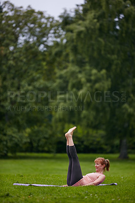 Buy stock photo Shot of a woman doing yoga in the park