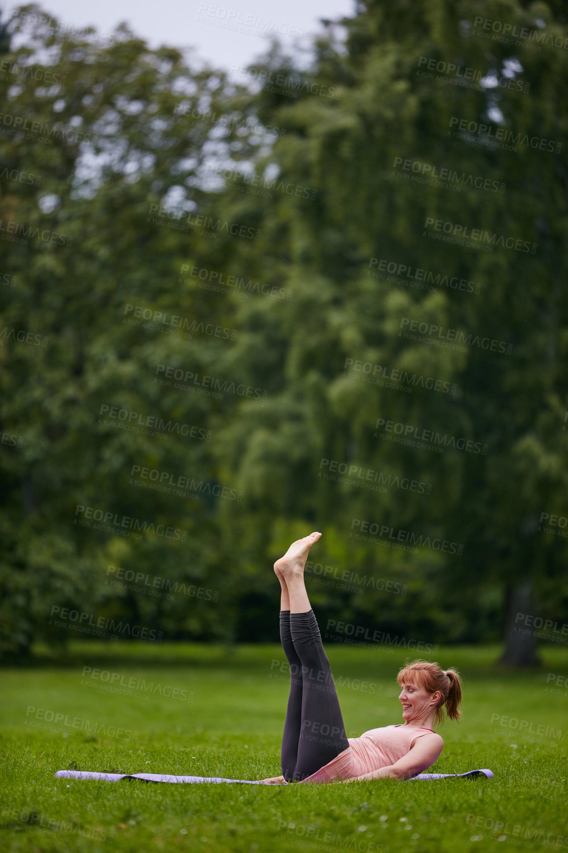 Buy stock photo Shot of a woman doing yoga in the park