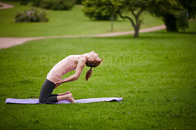 Buy stock photo Shot of a woman doing yoga in the park