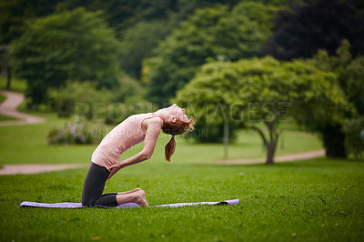 Buy stock photo Shot of a woman doing yoga in the park